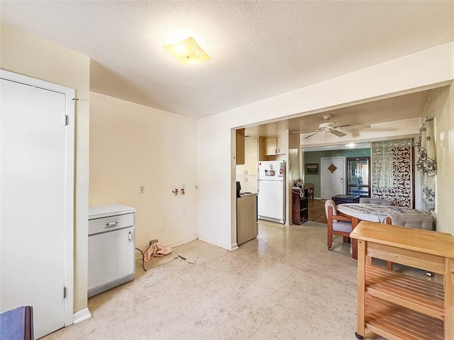 kitchen with ceiling fan, white fridge, and a textured ceiling