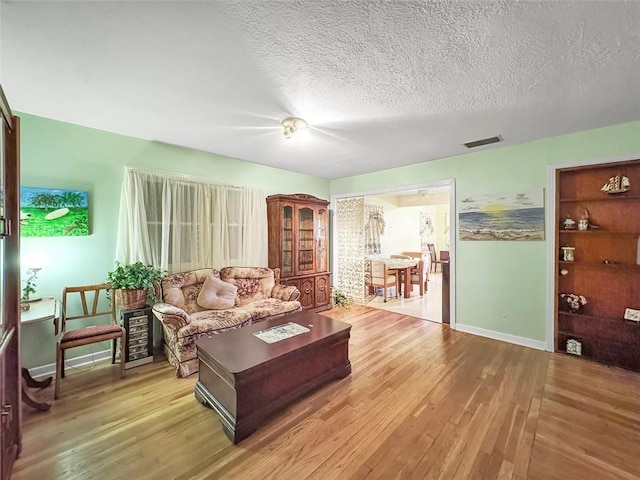 living room with light hardwood / wood-style flooring and a textured ceiling