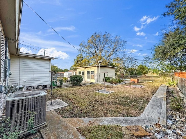 view of yard featuring central AC unit and an outbuilding