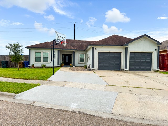 ranch-style home with a garage and a front lawn