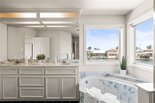 13726 Cayo Gorda Ct, Corpus Christi, TX 78418 - full bath with double vanity, a water view, a sink, and a bath