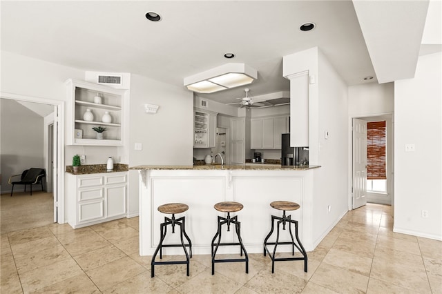 13726 Cayo Gorda Ct, Corpus Christi, TX 78418 - kitchen featuring a breakfast bar, visible vents, ceiling fan, a peninsula, and fridge with ice dispenser