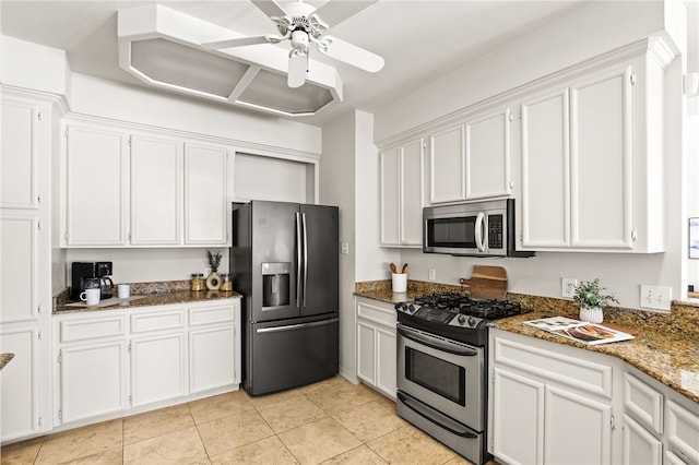 13726 Cayo Gorda Ct, Corpus Christi, TX 78418 - kitchen with stainless steel appliances, dark stone countertops, ceiling fan, light tile patterned floors, and white cabinets