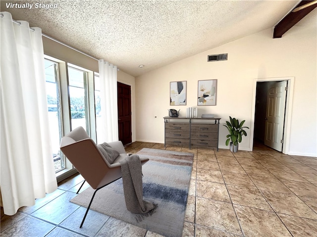 living area featuring a textured ceiling and vaulted ceiling with beams