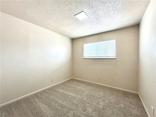 carpeted empty room featuring a textured ceiling