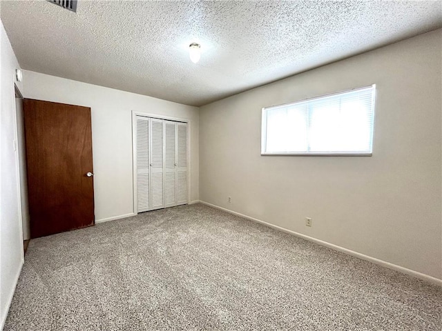 unfurnished bedroom featuring carpet floors, a closet, and a textured ceiling