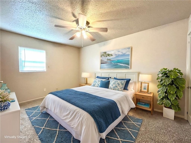 bedroom featuring ceiling fan, dark carpet, and a textured ceiling