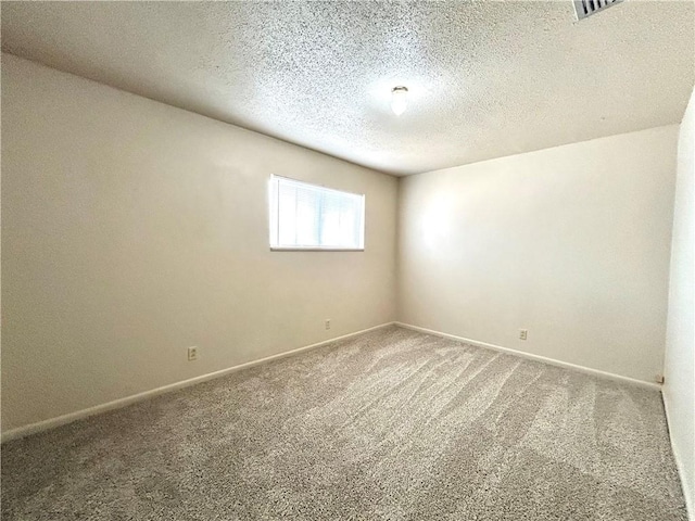 empty room featuring a textured ceiling and carpet flooring