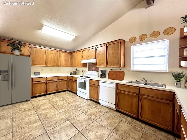 kitchen featuring lofted ceiling, sink, a textured ceiling, light tile patterned floors, and white appliances