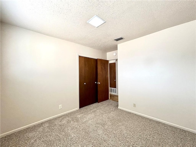 spare room featuring a textured ceiling and carpet