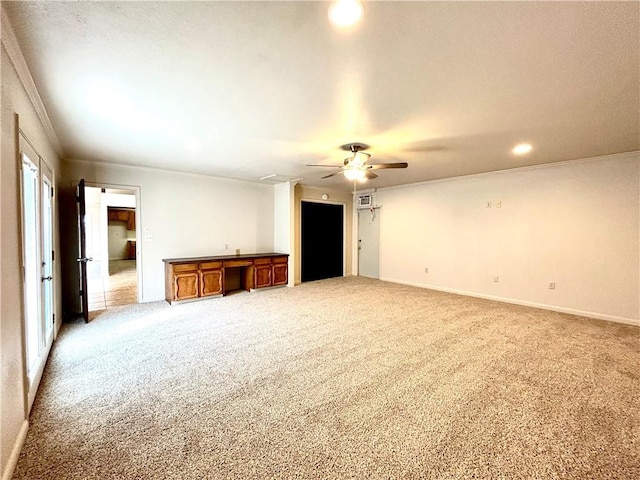 carpeted empty room featuring crown molding, built in desk, and ceiling fan