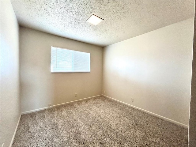 spare room featuring a textured ceiling and carpet