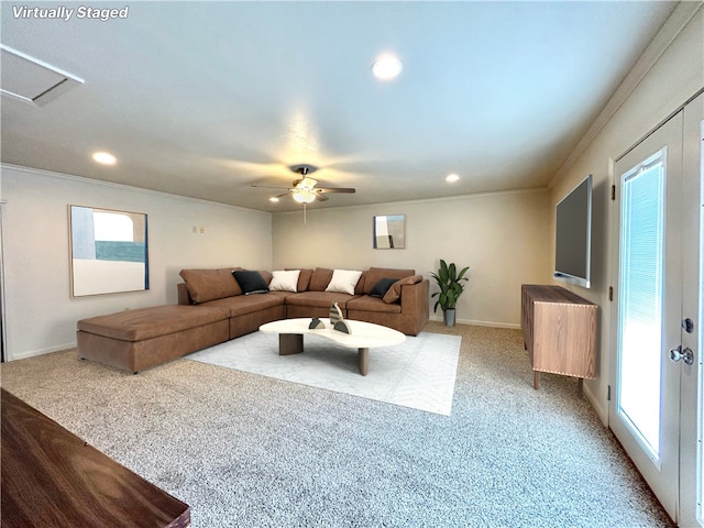 carpeted living room with crown molding and ceiling fan