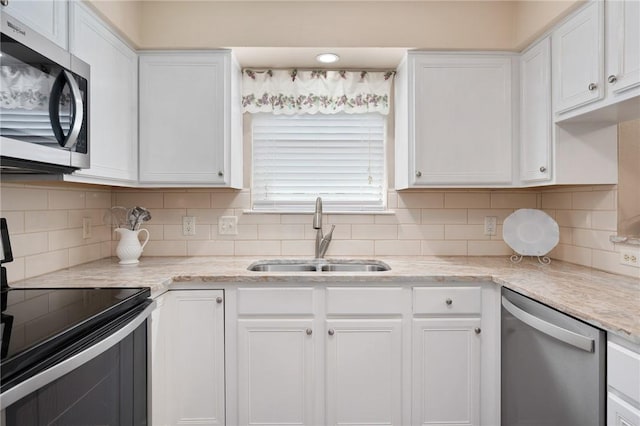 2301 Cyprus Dr, Ingleside, TX 78362 - kitchen with appliances with stainless steel finishes, a sink, and white cabinets