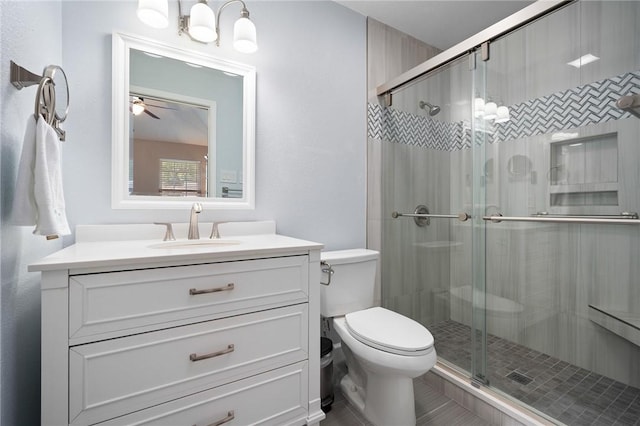 2301 Cyprus Dr, Ingleside, TX 78362 - full bath featuring a stall shower, toilet, vanity, and a ceiling fan