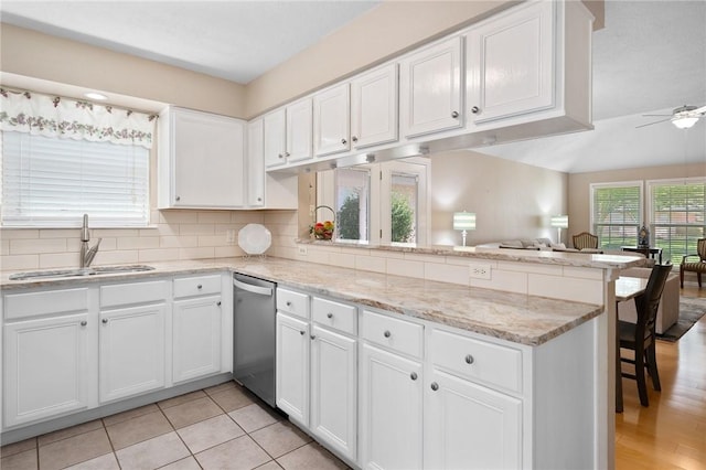 2301 Cyprus Dr, Ingleside, TX 78362 - kitchen featuring stainless steel dishwasher, a peninsula, a sink, open floor plan, and white cabinets