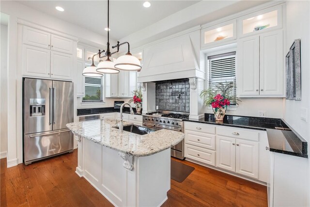 134 La Joya Prt, Aransas, TX 78373 - kitchen featuring premium appliances, a sink, white cabinets, custom exhaust hood, and dark wood-type flooring