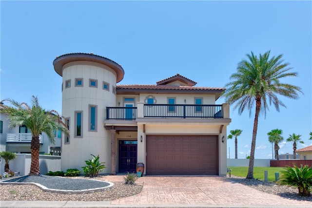 mediterranean / spanish-style home with a garage and a balcony