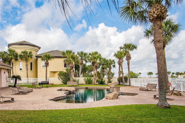 view of swimming pool featuring a lawn and a patio