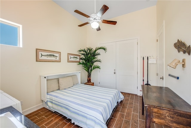 bedroom featuring dark wood-type flooring, a closet, high vaulted ceiling, and ceiling fan