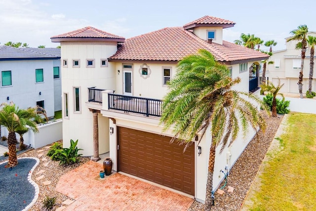 134 La Joya Prt, Aransas, TX 78373 - mediterranean / spanish house featuring a balcony, a tile roof, stucco siding, fence, and a garage