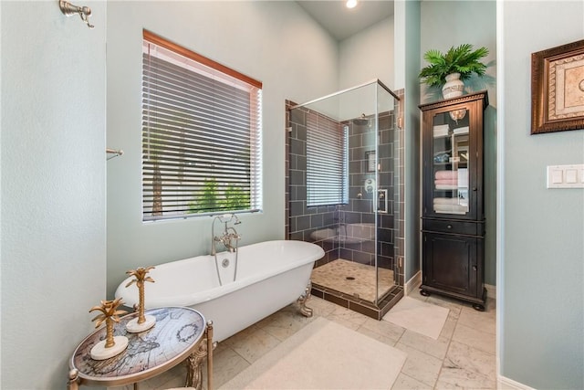 134 La Joya Prt, Aransas, TX 78373 - bathroom featuring a shower stall, a freestanding bath, and baseboards