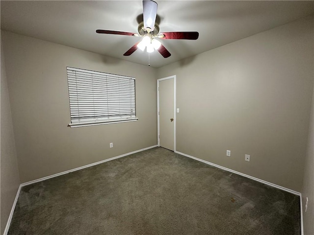 carpeted spare room featuring a ceiling fan and baseboards