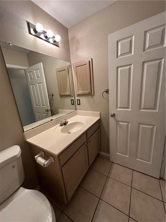 bathroom with tile patterned flooring, toilet, and vanity