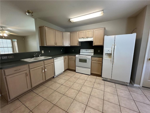 kitchen featuring white appliances, light brown cabinets, a sink, under cabinet range hood, and dark countertops