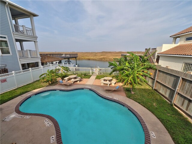 view of pool with a patio area and a water view