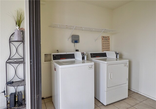 laundry area with washer and clothes dryer and light tile patterned floors