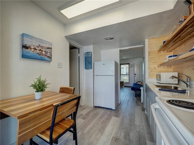 dining area featuring light wood-type flooring and sink