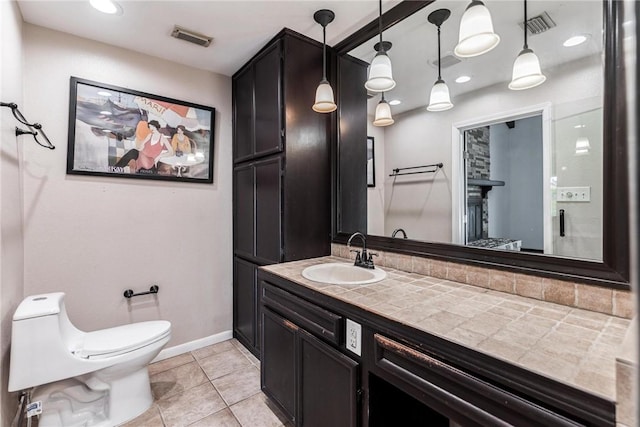 bathroom with toilet, tile patterned flooring, vanity, baseboards, and recessed lighting
