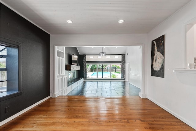 hallway with hardwood / wood-style flooring, crown molding, and plenty of natural light