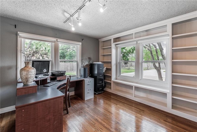 office featuring a textured ceiling, wood finished floors, baseboards, built in features, and rail lighting