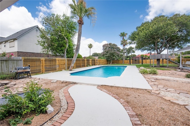 view of swimming pool with area for grilling, a playground, and a patio area