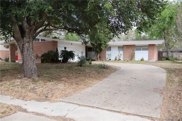 109 Kissling Ave, Robstown, TX 78380 - view of front facade featuring brick siding, curved driveway, and an attached garage