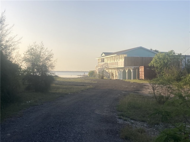 view of road featuring a water view and stairway