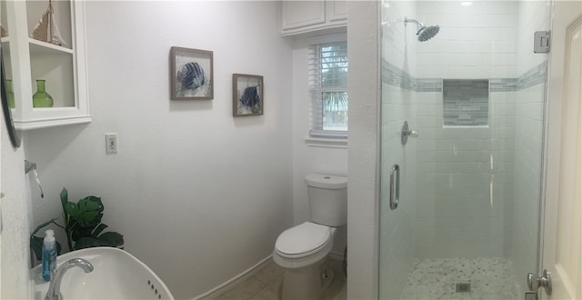 full bathroom with a stall shower, toilet, baseboards, and a sink