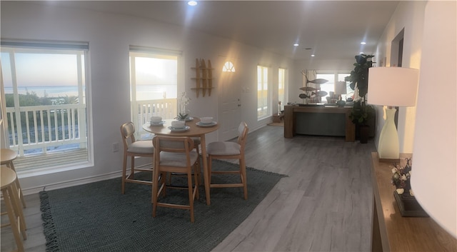 dining area with baseboards, wood finished floors, and recessed lighting