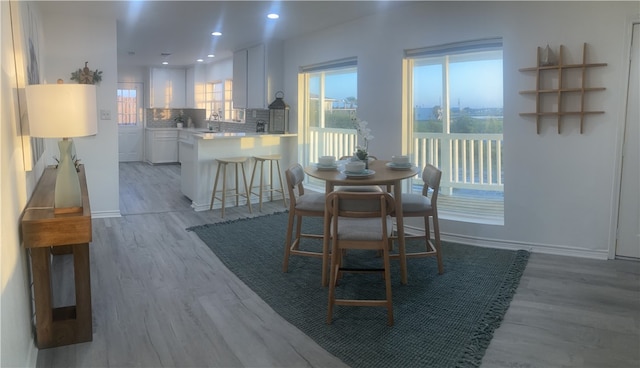 dining area with light wood-style floors, recessed lighting, and baseboards