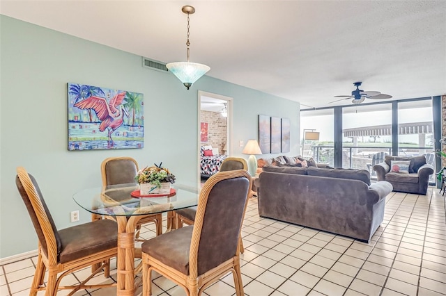 tiled dining area with ceiling fan and floor to ceiling windows