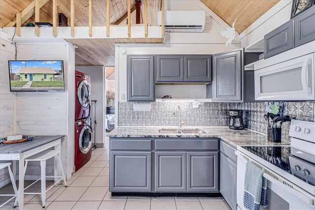 kitchen with white appliances, wood ceiling, stacked washer / drying machine, gray cabinets, and light tile patterned flooring