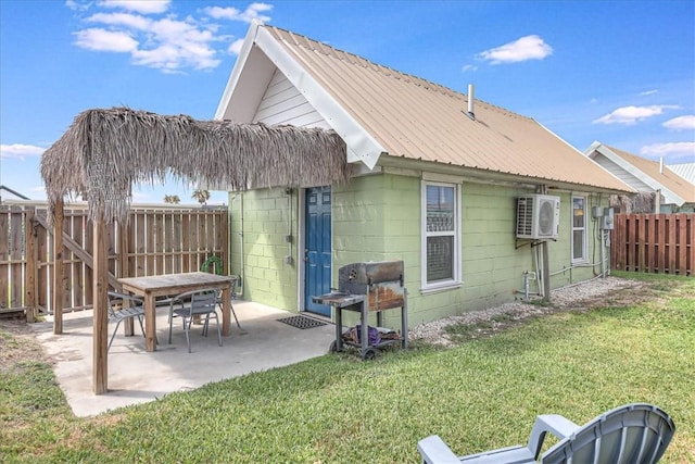 back of property with a patio, a lawn, and ac unit