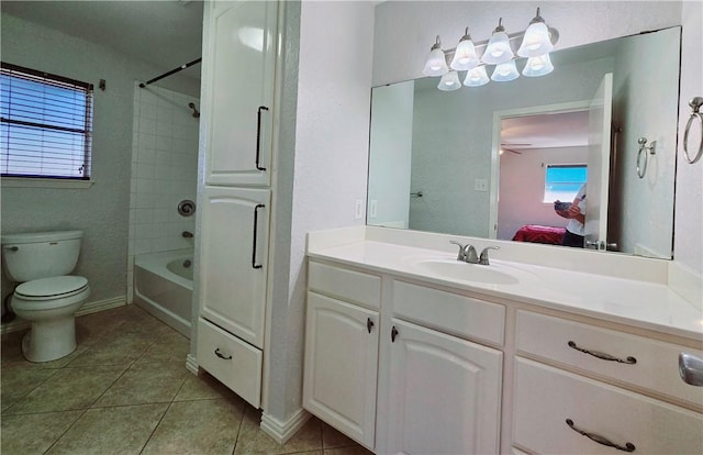 full bathroom with ceiling fan, tiled shower / bath combo, tile patterned floors, toilet, and vanity