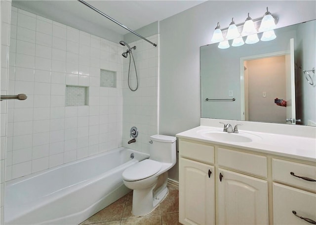 full bathroom featuring tile patterned floors, tiled shower / bath, vanity, and toilet