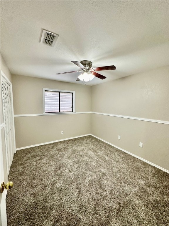 carpeted empty room featuring a textured ceiling and ceiling fan