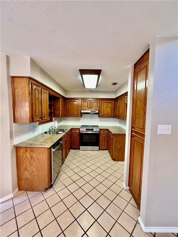 kitchen with sink, appliances with stainless steel finishes, a textured ceiling, and light tile patterned floors