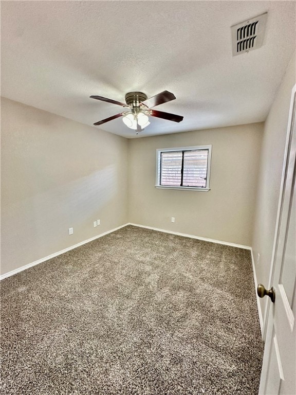 carpeted empty room with ceiling fan and a textured ceiling