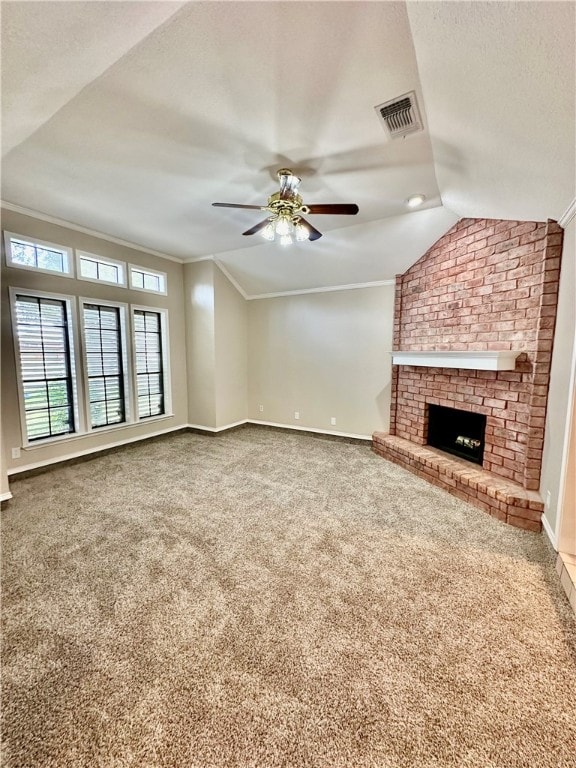 unfurnished living room with a fireplace, crown molding, carpet floors, vaulted ceiling, and ceiling fan